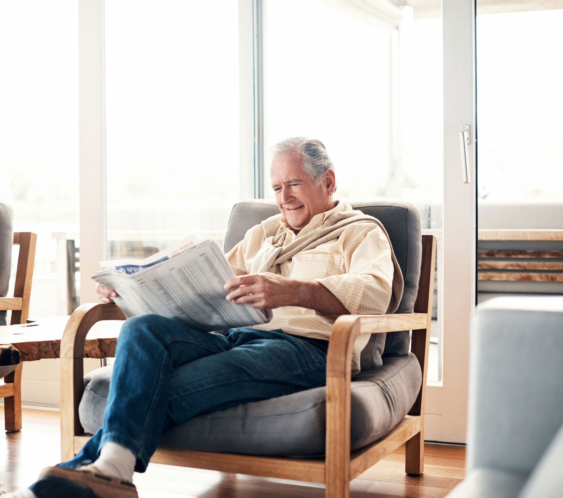 Man leest krant in woonkamer - afgesneden